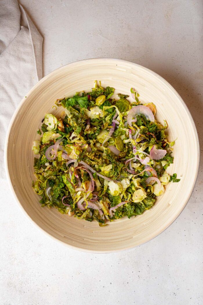 Warm salad base in a large salad bowl.