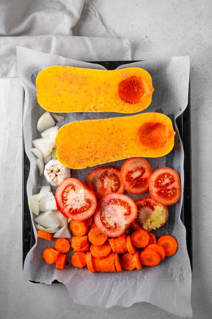 Vegetables laid out on a sheet pan with basic spices.