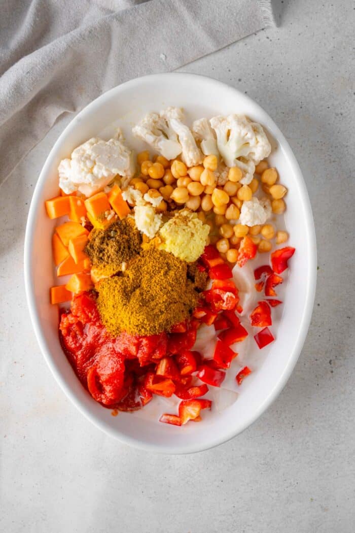 All of the curry ingredients together in a casserole dish.