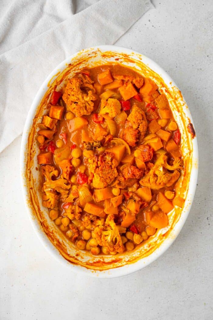 Cooked roasted vegetable curry in a casserole dish.