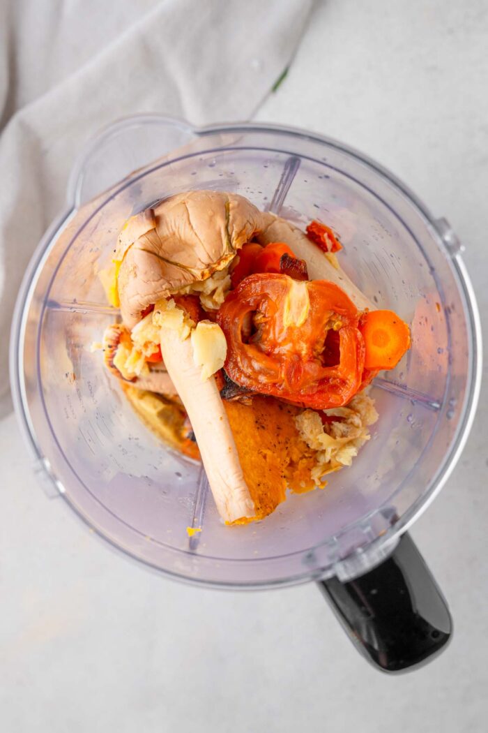 Roasted vegetables in a high-speed blender, shot from above.