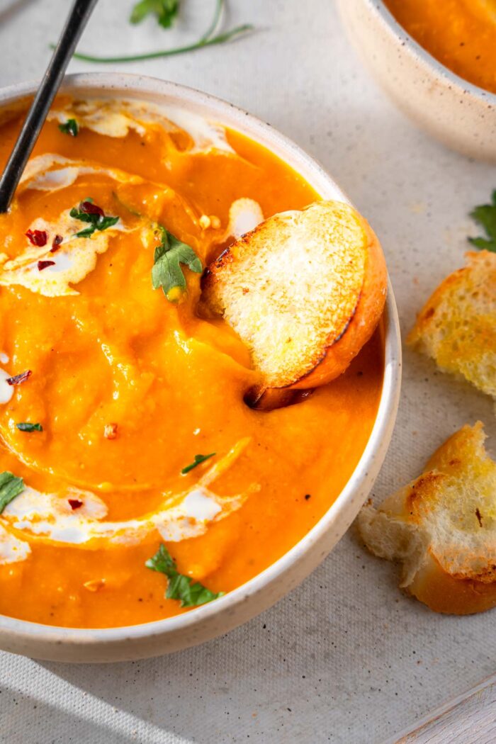 Some bread dipped in butternut squash soup.