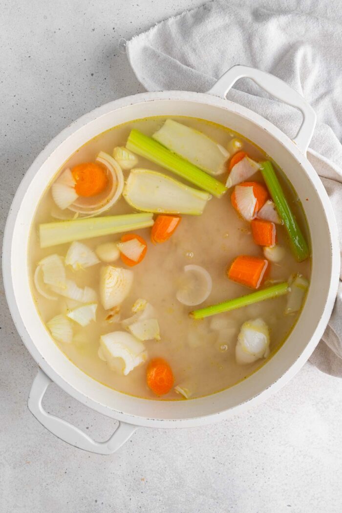 Roughly chopped vegetables in a pan with vegetable broth.