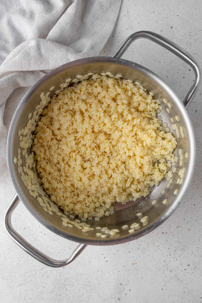 Cooked pastina in a steel pot.