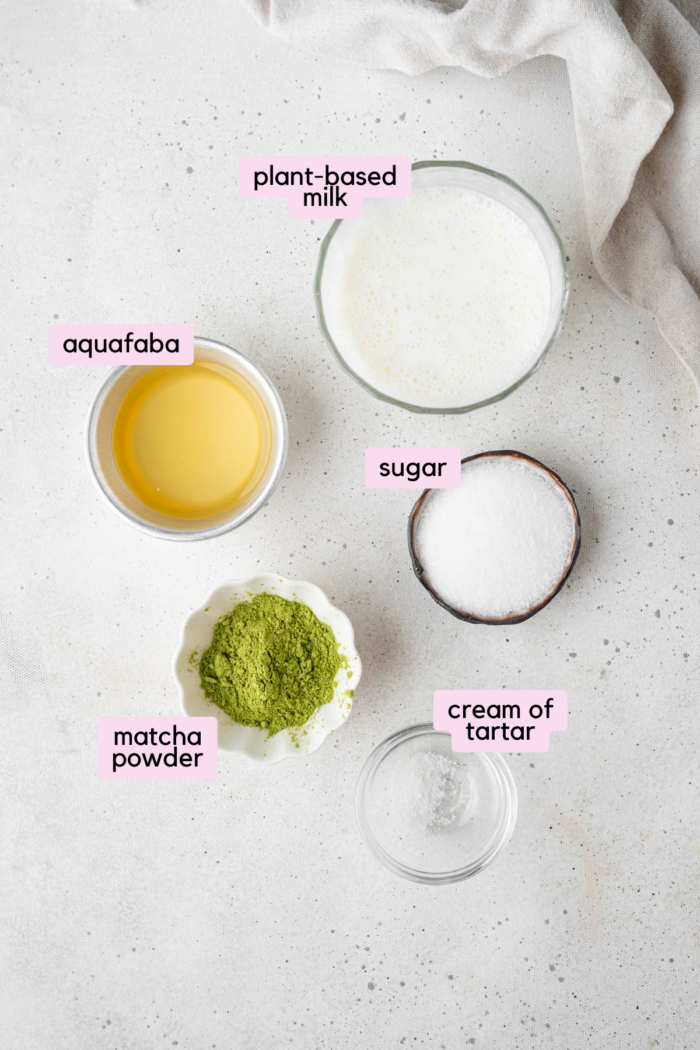 Whipped dalgona matcha ingredients laid out and labeled on a light background.