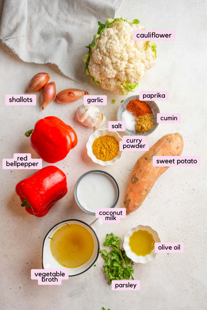 Ingredients for sweet potato cauliflower soup laid out on a light background and labeled.