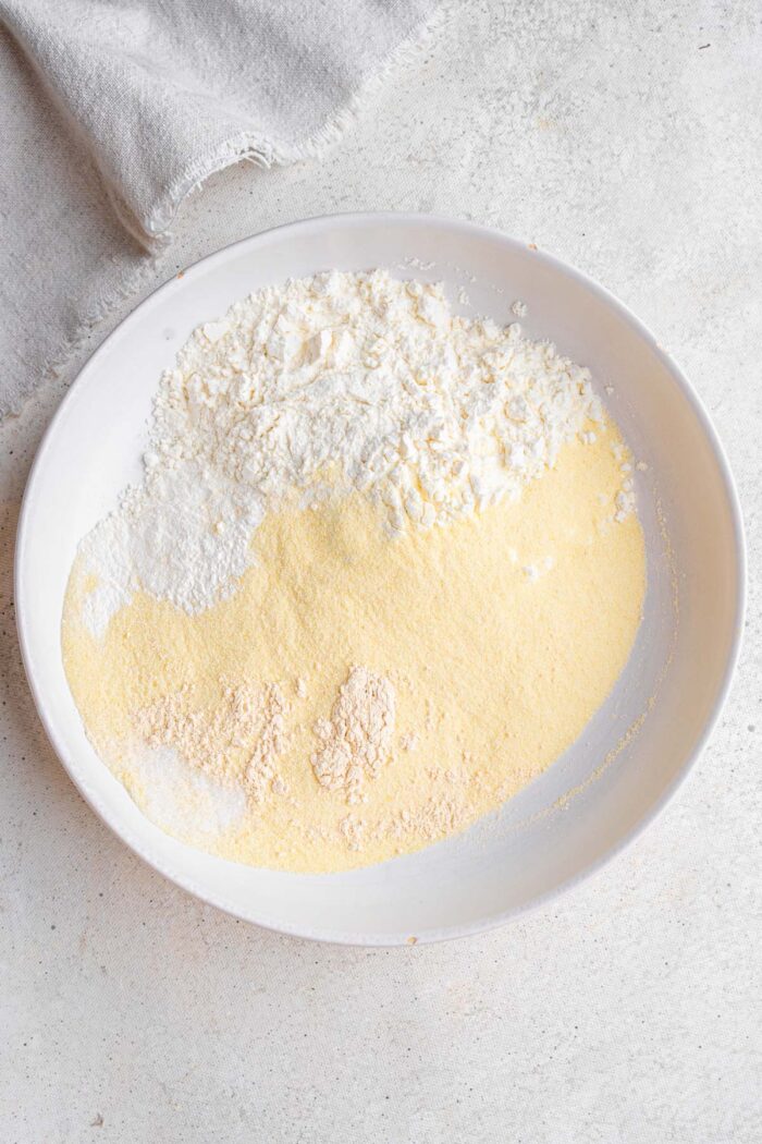 Cornbread crust ingredients in a white ceramic bowl.