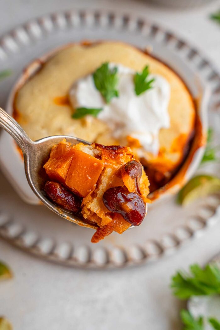 A spoonful of sweet potato black bean chili lifted out of the ramekin.