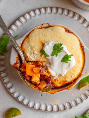 A spoonful of sweet potato black bean chili lifted out of the ramekin.