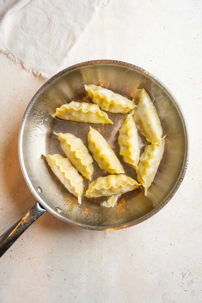 Potsticker dumplings ina steel frying pan.