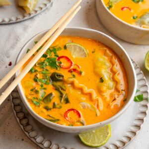 Easy Red Curry Soup served in a ramen bowl with chopsticks resting on the side.