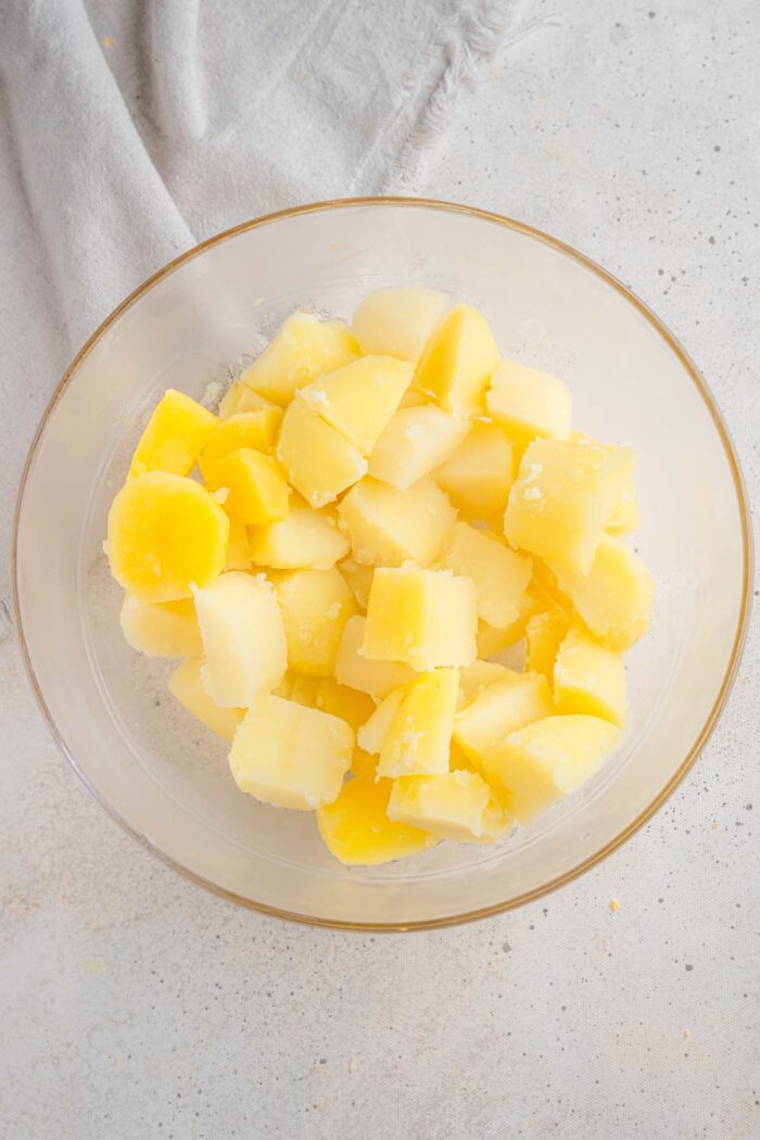 Boiled potato chunks in a glass bowl.