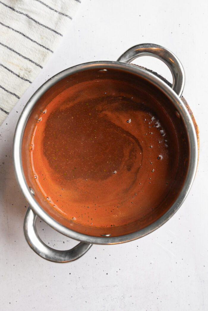 Glossy vegan gravy in a steel pot.