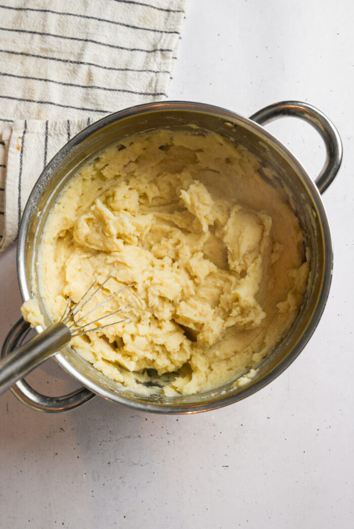 Final stage of making vegan mashed potatoes: a whisk creating the desired texture.