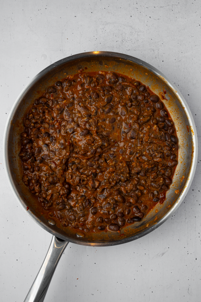 Mashed black bean mixture in the frying pan.