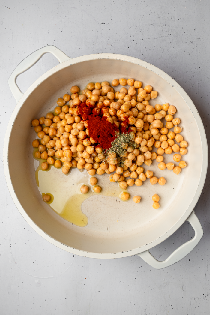 Chickpeas and spices in a non-stick pan.