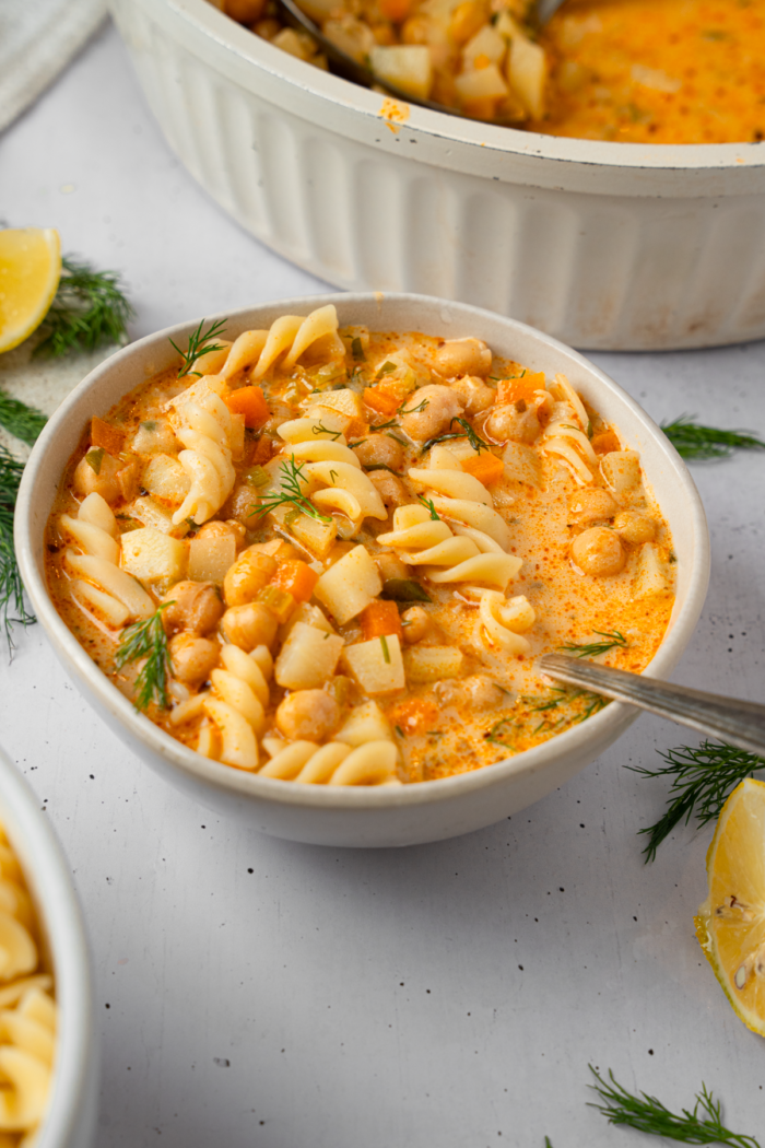 A large serving of creamy vegetable soup with noodles.