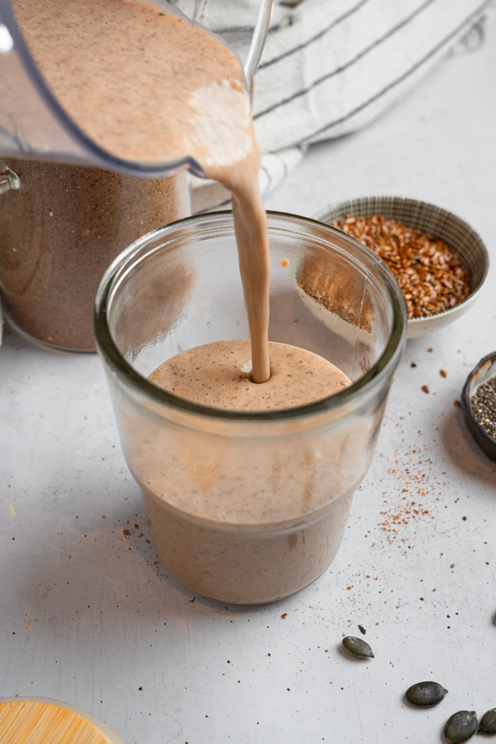 Vegan chocolate frosty being poured into a glass.