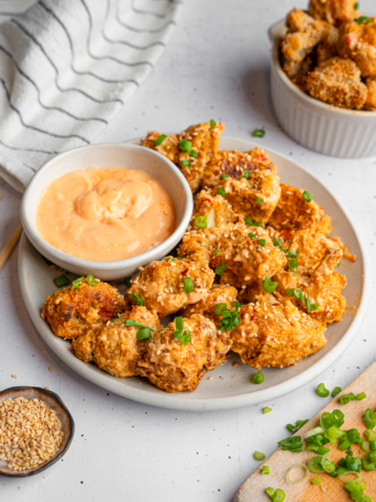 Bang bang cauliflower served on a platter with sauce on the side.