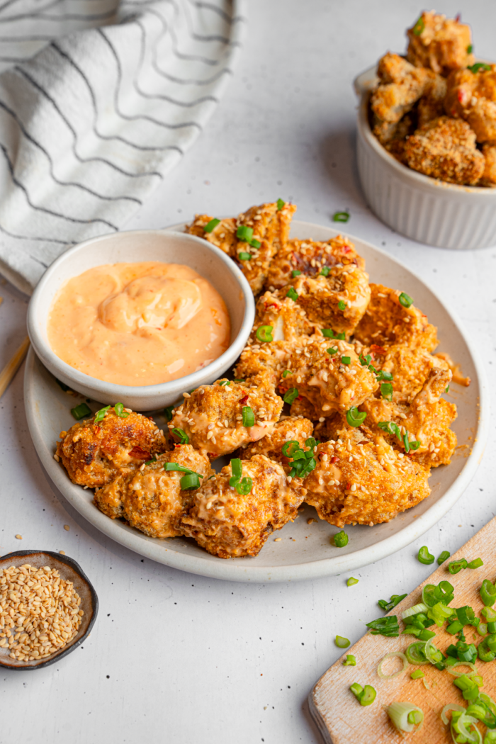 Bang bang cauliflower served on a platter with sauce on the side.