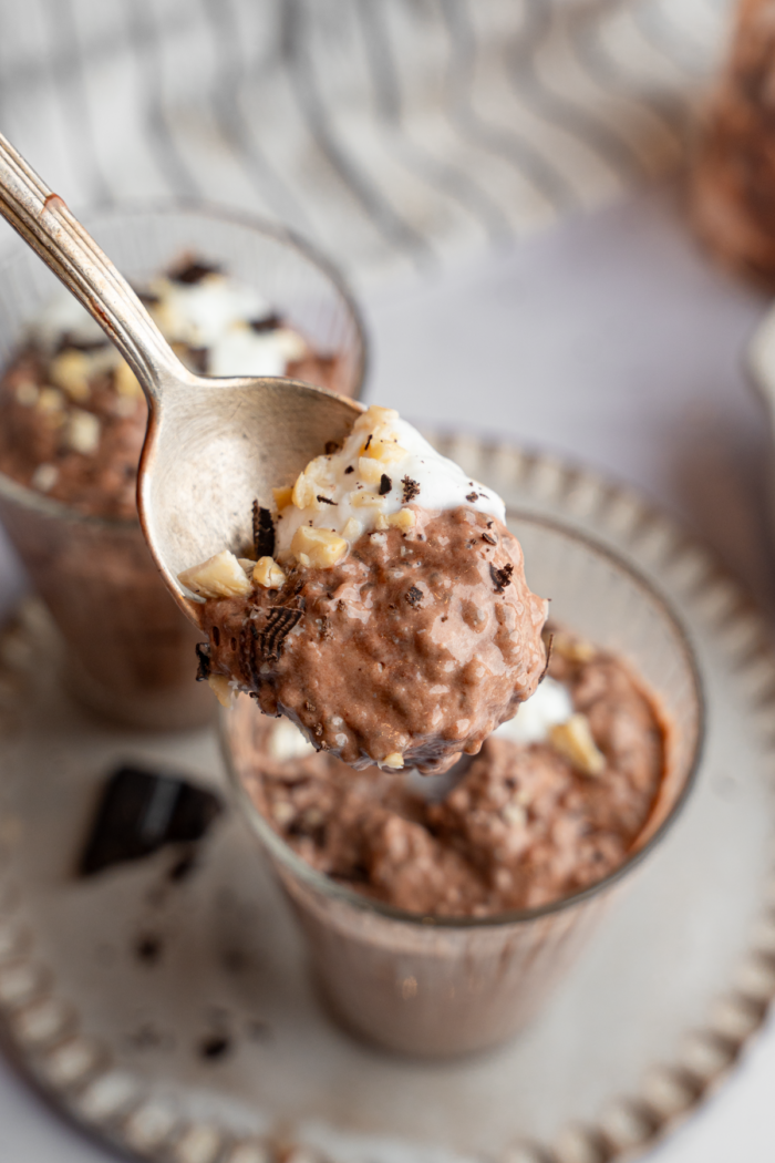 A spoonful of chocolate chia pudding, with the rest visible in the background.