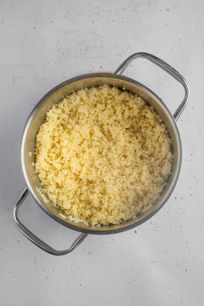 Couscous cooked in a steel pan.