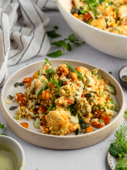 Sweet potato and cauliflower herb couscous salad served in a shallow bowl.