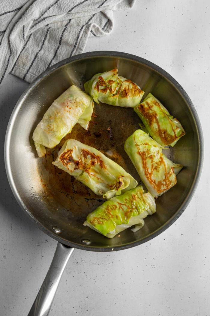 Cooked vegan cabbage wrapped dumplings, with a browned, crispy outside facing up.