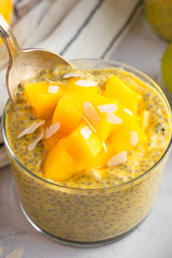 A spoon scooping up some mango chia pudding.