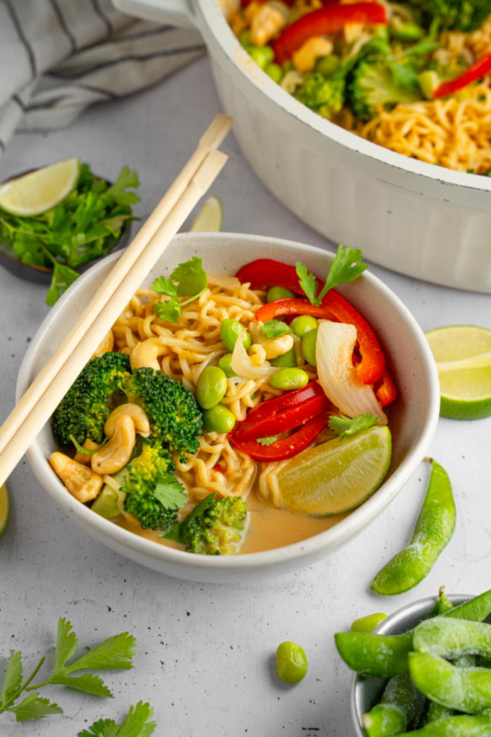 A serving of one pan curry noodles with chopsticks resting on the side of the bowl.
