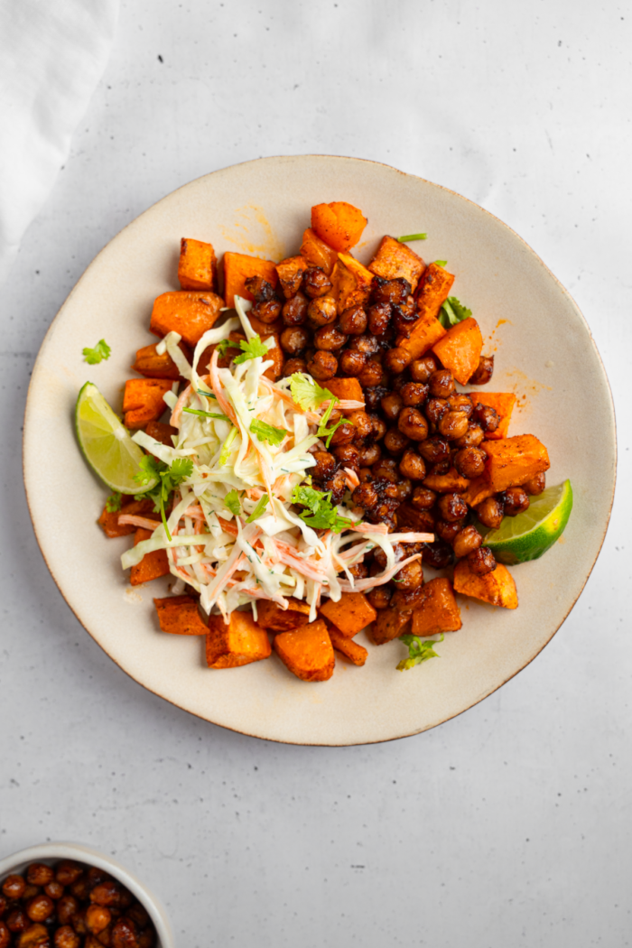 Coleslaw added to the bowl along with lime wedges.
