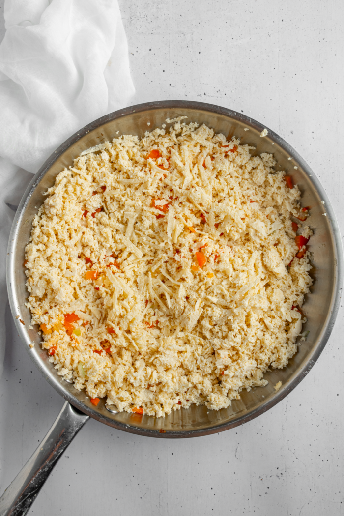 Grated tofu added to the pan with aromatics and bell pepper.