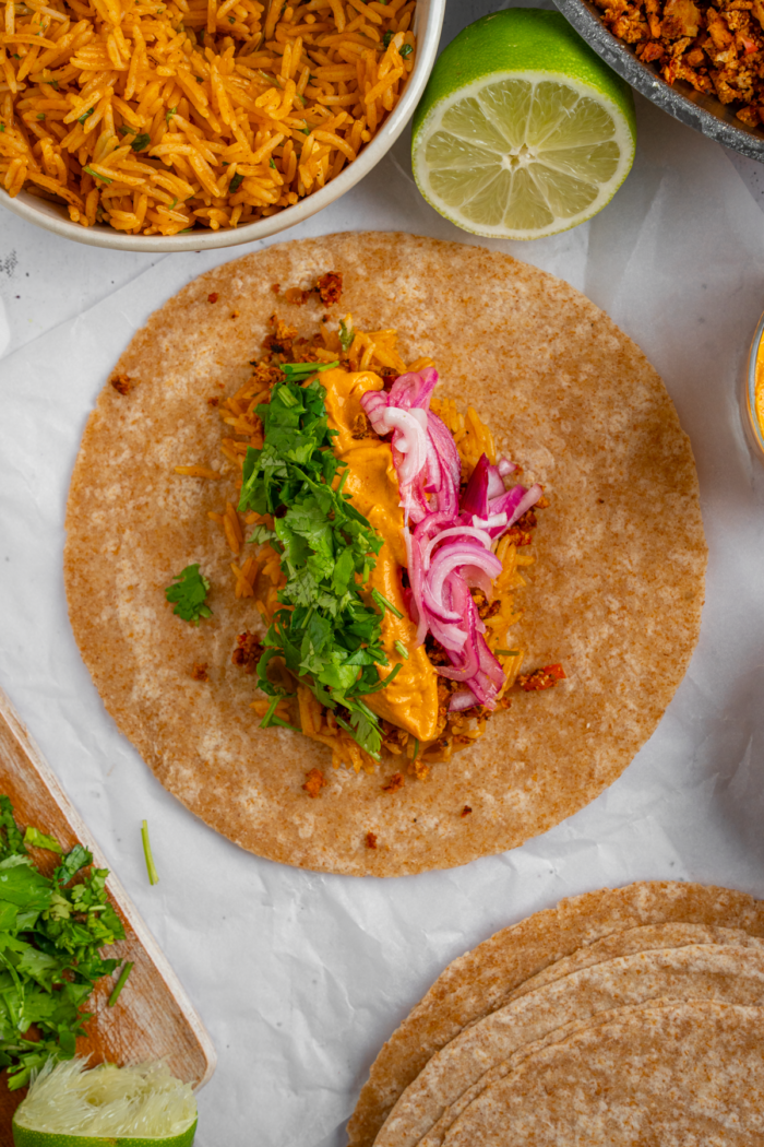 Fresh cilantro, pickled onions, and jalapenos added to vegan meal prep burritos.