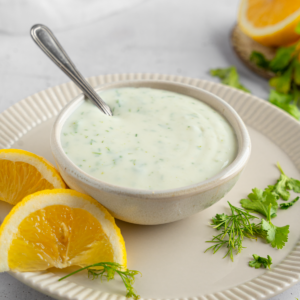 Vegan ranch dressing in a small dipping bowl with a spoon sticking out.