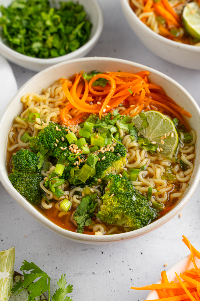 Spring noodle soup served in a large white ceramic ramen bowl.