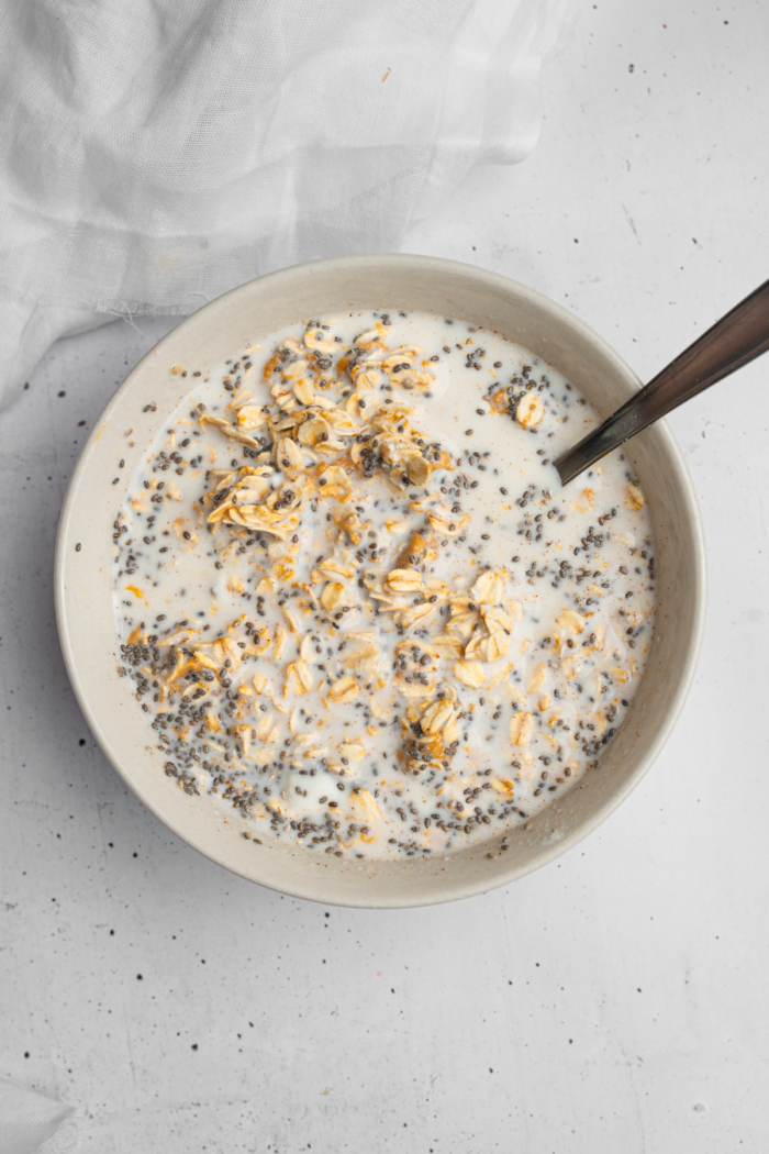 The components of the overnight oats mixed together in a bowl.