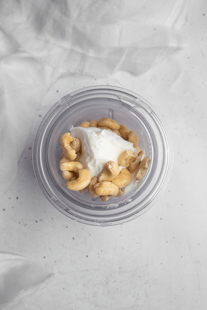 Cashew cream cheese frosting ingredients in a high-speed blender.