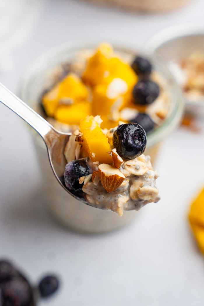 A spoonful of high protein overnight oats at the forefront, with the rest of the serving visible in the background.