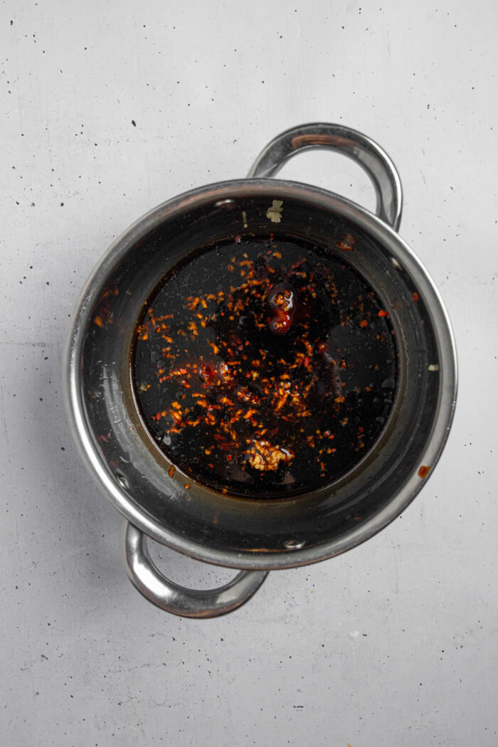 Sticky "honey" garlic sauce ingredients in a small steel saucepan.