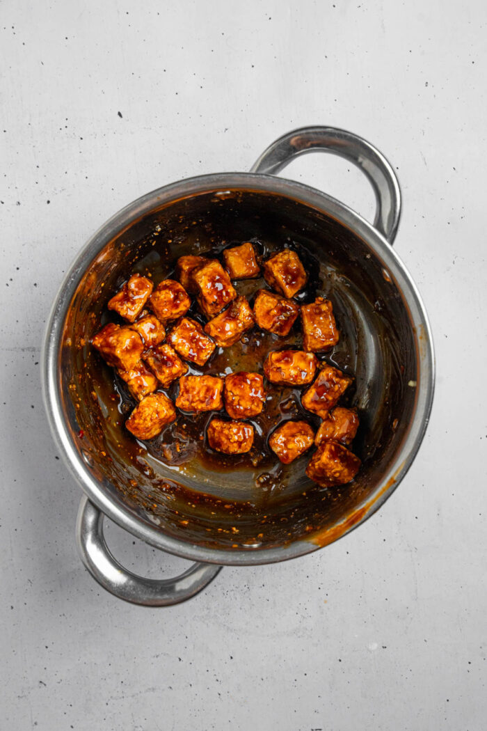 Tofu cubes coated in "honey" garlic sauce.