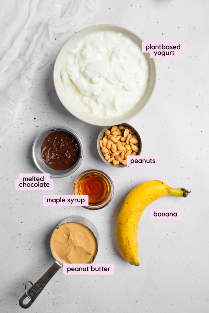 Ingredients for the peanut butter yogurt bark laid out and labeled on a light background.