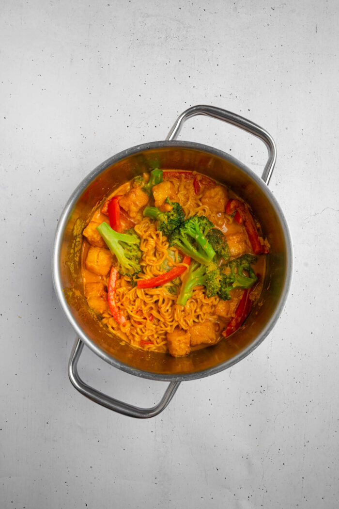 A cooked pot of creamy Thai red curry noodles.