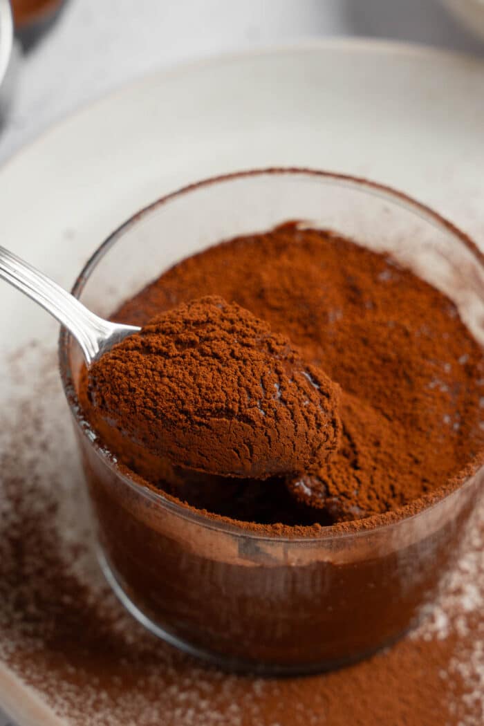 A spoonful of rice chocolate pudding being lifted out of the dessert cup.