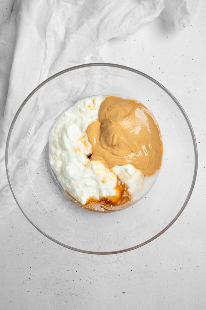 Ingredients for the base of the peanut butter yogurt bark in a glass mixing bowl.