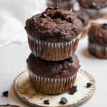 Two hidden veggie muffins stacked on top of each other, more muffins visible in the background.