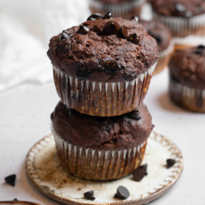 Two hidden veggie muffins stacked on top of each other, more muffins visible in the background.