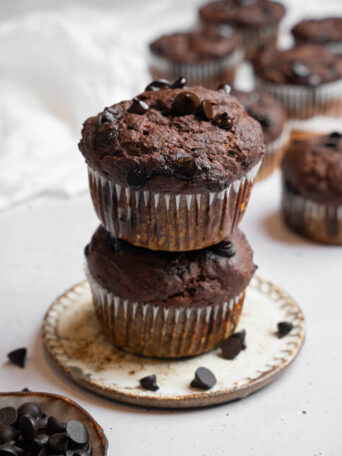 Two hidden veggie muffins stacked on top of each other, more muffins visible in the background.