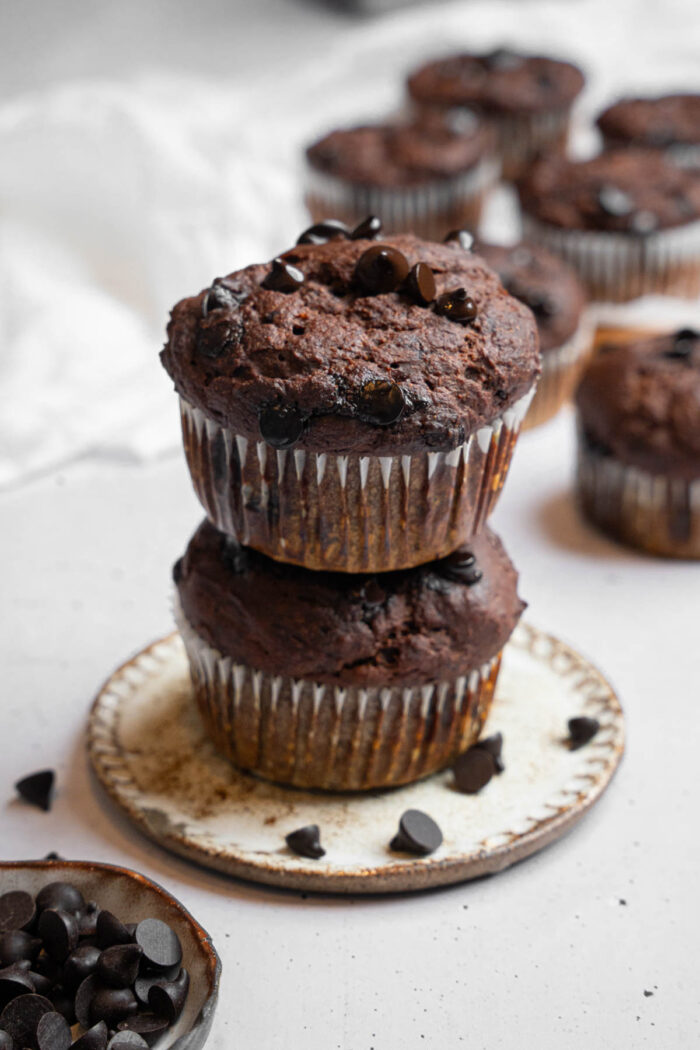 Two hidden veggie muffins stacked on top of each other, more muffins visible in the background.