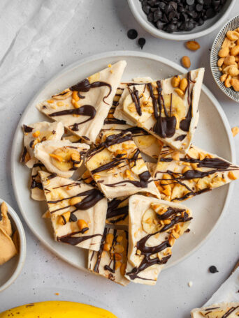Peanut butter yogurt bark broken into pieces and served on a plate.
