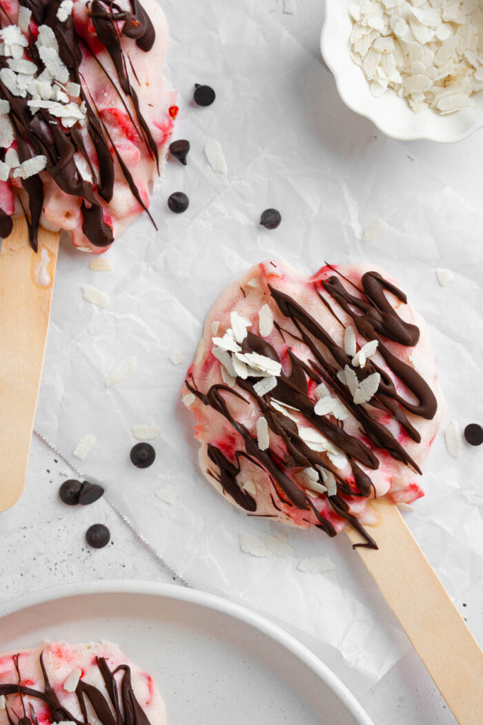 Strawberry yogurt clusters, vegan and kid-friendly, drizzled with chocolate and coconut sprinkles.